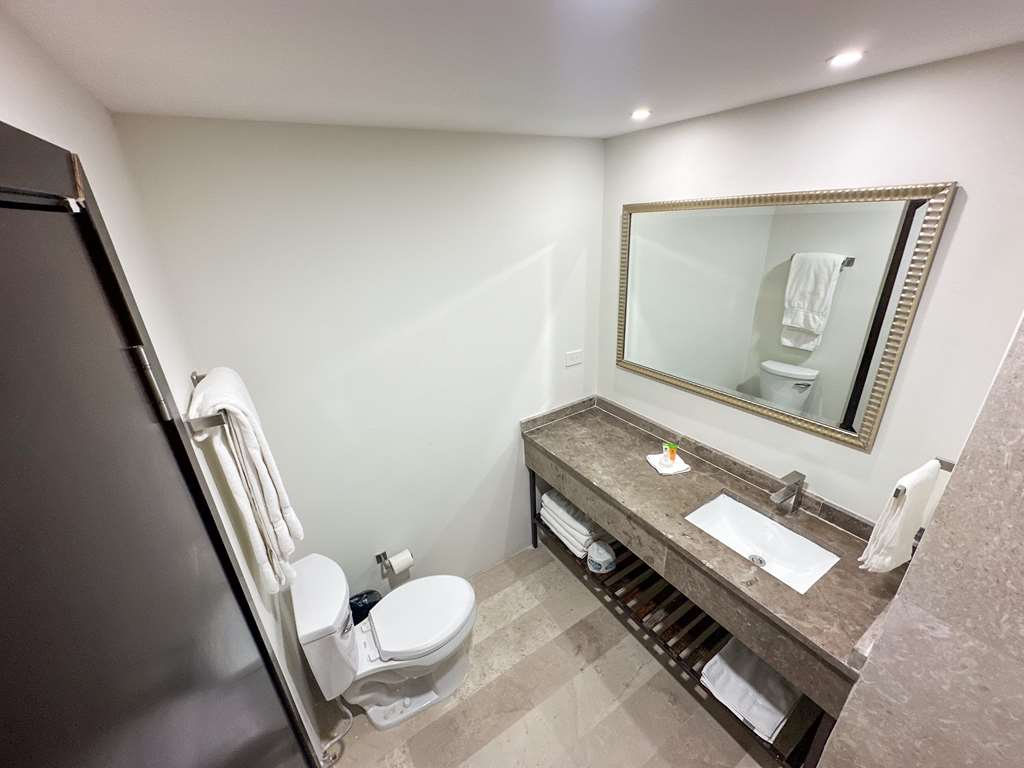 The bathroom combines style and comfort with a spacious shower, a bright vanity, and high-quality towels. It's a perfect space to unwind.