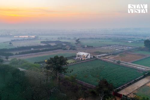 StayVista at Olive Farms with Lawn Pool Bonfire & Hill Views