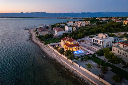 Beach front villa with heated pool jacuzzi fantastic view the sound of the waves by Traveler tourist agency Krk ID 2404 — 4-Star Luxury Hotel in Privlaka, Croatia