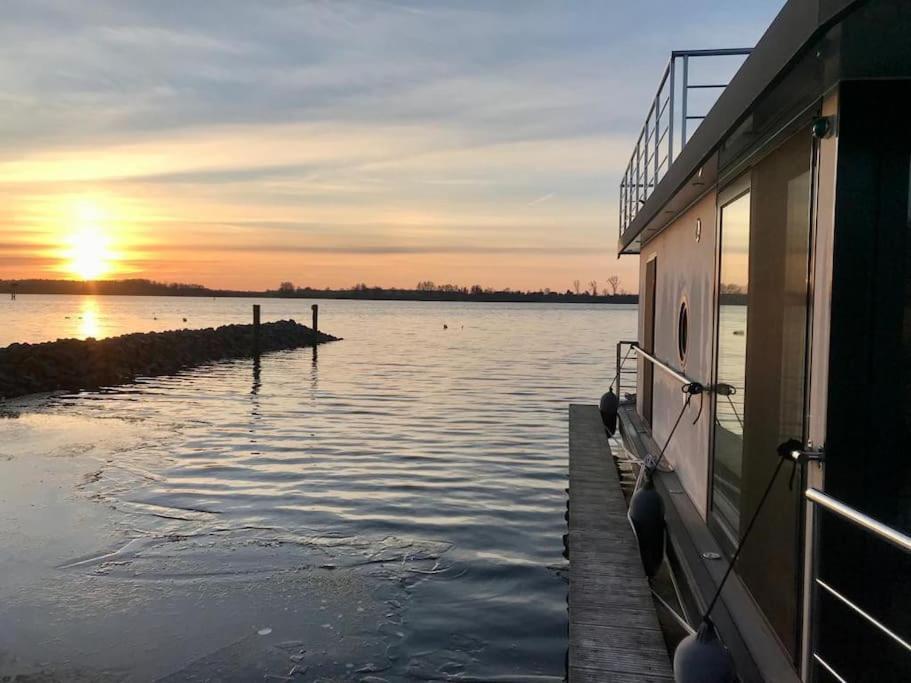 Modernes festliegendes Hausboot mit großzügiger Dachterrasse und Ruderboot - last minute hotel in Unknown City