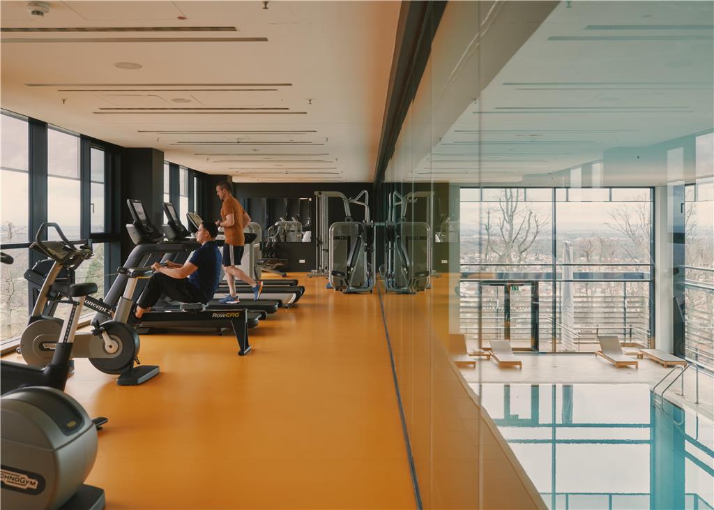 Fitness room with various equipment and views of the park, indoor pool