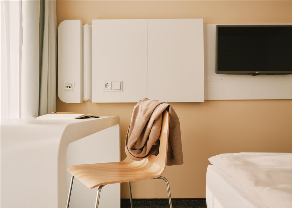 Desk, Chair with a jacket over the backrest, TV